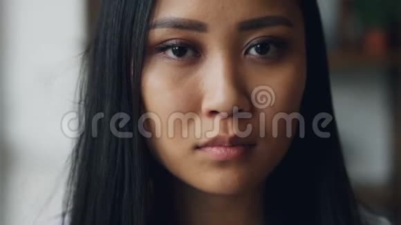 特写慢镜头肖像迷人的亚洲女孩黑眼睛完美的皮肤化妆和白色的牙齿看着视频的预览图