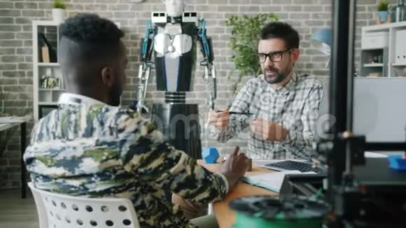 年轻商人讨论现代办公机器人的3d打印细节视频的预览图