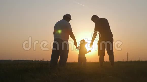 小男孩与父亲和祖父在日落剪影概念一家三代人视频的预览图