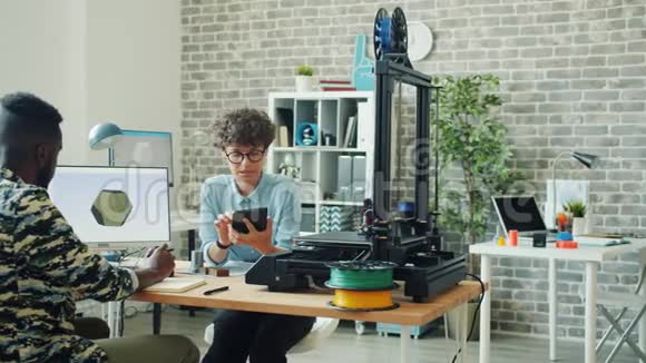办公室里使用平板电脑电脑和3d打印机的同事在谈话视频的预览图