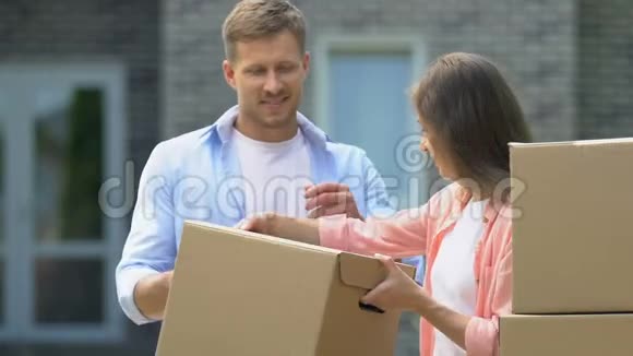 年轻的妻子给丈夫纸箱幸福的家庭搬家房屋所有权视频的预览图