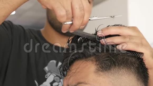 专业理发师在工作中发型师用剪刀剪客户头发视频的预览图