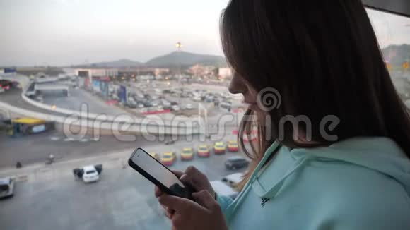 年轻女性乘公共汽车旅行点击智能手机女孩在车窗前的车里旅行视频的预览图