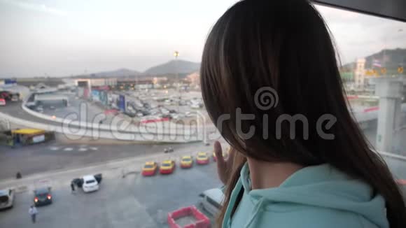 年轻的白种人女性旅行者从终点站的窗口望出去期待着4K的冒险视频的预览图