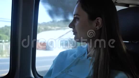 年轻女子乘公共汽车去看窗户女孩在车窗前的车里旅行视频的预览图