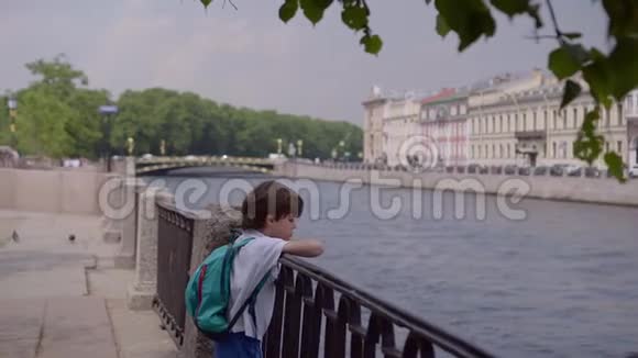 英俊的男孩把手放在丰坦卡河的金属栅栏上崇拜城市视频的预览图