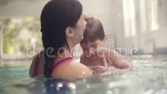 可爱的宝宝和他妈妈一起上游泳课妈妈教儿子去游泳池游泳年轻妈妈视频的预览图