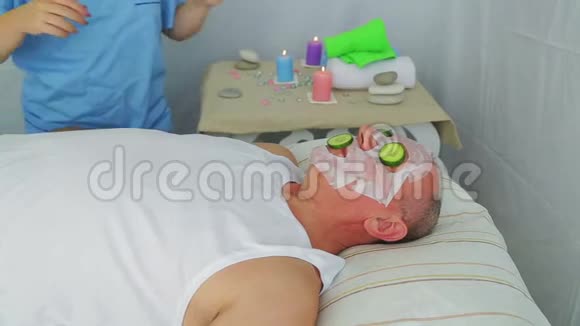女性美容师在男人脸上做蔬菜疗法视频的预览图