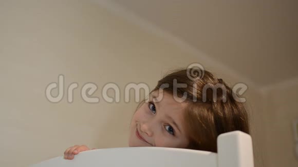 小女孩微笑着打着哈欠在床上睡着了视频的预览图