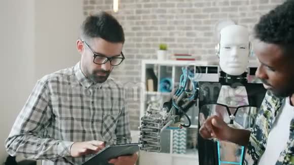 快乐工程师在办公室测试机器人在室内使用现代机器视频的预览图