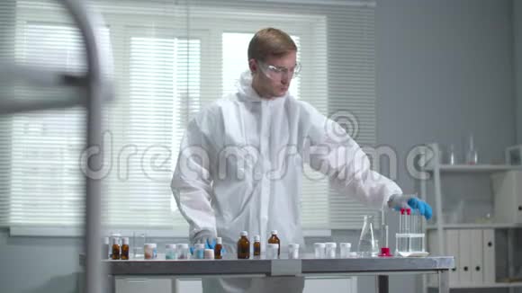 戴防护工作服和手套的人在实验室中使用化学设备视频的预览图