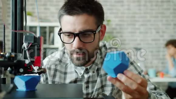 男性研究员观看3d打印机制作塑料细节享受过程视频的预览图