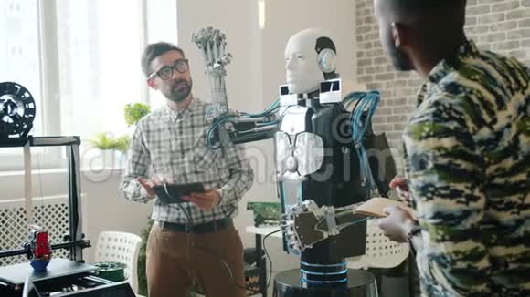 伙计们用平板电脑测试酷酷机器人3d打印机在后台工作视频的预览图