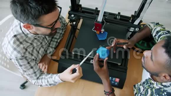男性专家讨论3D打印模型观察打印机工作的最高看法视频的预览图