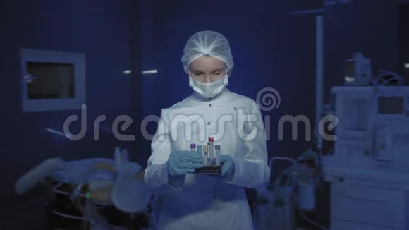 年轻女医生戴着医用面具看镜头的肖像医生手里拿着锥子视频的预览图