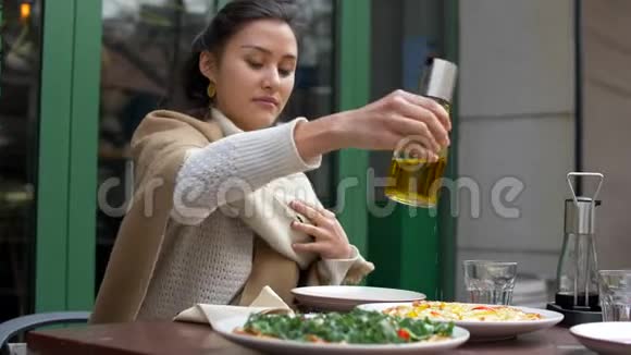漂亮的年轻混合女人在披萨店外桌上餐厅4k视频的预览图