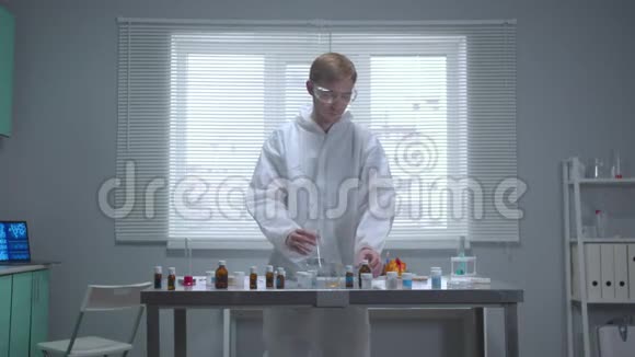 穿着防护服的人在实验室里把液体倒入管子里视频的预览图