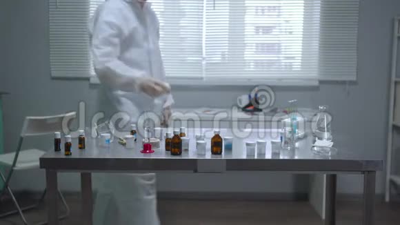 在实验室里穿着防护工作服和口罩的人视频的预览图
