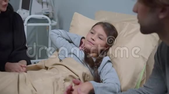 亲戚们前来看望和躺在医院床上的女孩交谈视频的预览图