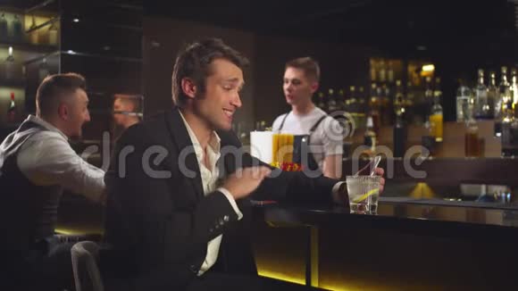 男人坐在酒吧里通过电话中的视频链接交谈视频的预览图