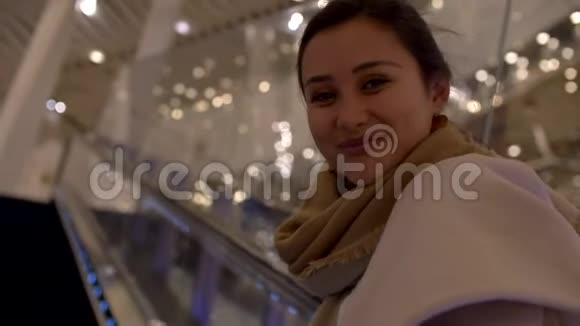 漂亮的年轻混合女子微笑在自动扶梯特写4k视频的预览图