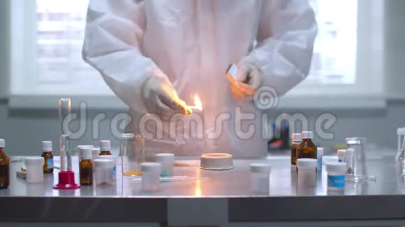 穿防护服的人在实验室里对桌子上的物质放火视频的预览图