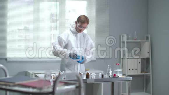 慢动作穿防护工作服的人和实验室里戴医用手套的人视频的预览图