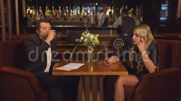 男人喝酒看着他的女人通过视频链接说话视频的预览图