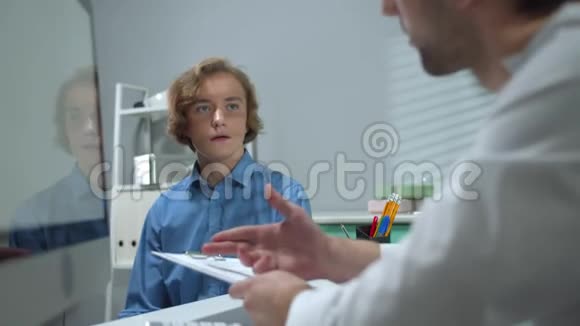 医生在医院的柜子里和男孩说话视频的预览图