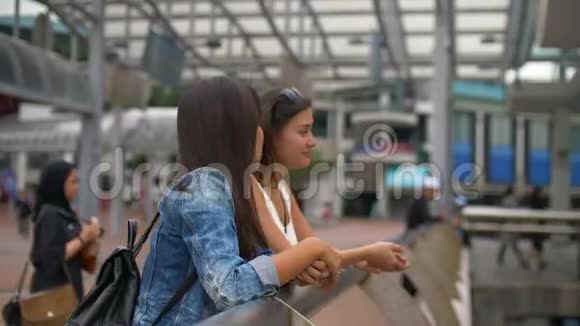 两个年轻的女朋友在拥挤的码头边谈笑风生视频的预览图
