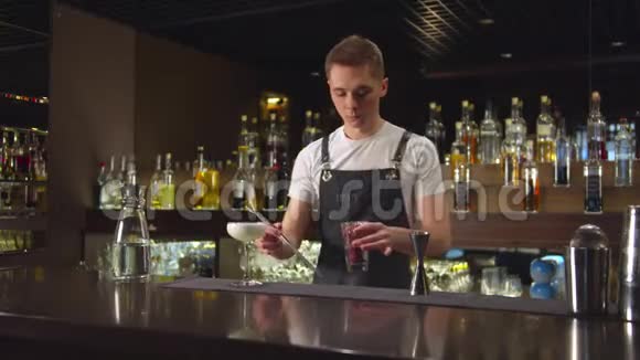 酒保把带钳子的浆果和酒精放在酒吧里视频的预览图