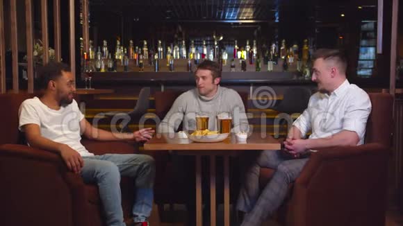 多元文化的朋友坐在酒吧喝啤酒聊天视频的预览图