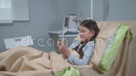 女孩躺在医院的床上玩药片视频的预览图