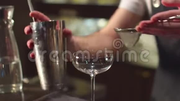 酒保通过酒吧的筛子将酒精倒入玻璃中视频的预览图