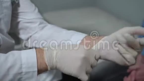男孩坐在医院的柜子里医生戴上了医疗手套视频的预览图