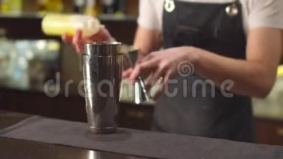 酒保将不同的糖浆倒入酒杯和摇床中视频的预览图
