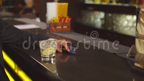 男人在酒吧用信用卡支付鸡尾酒的费用视频的预览图