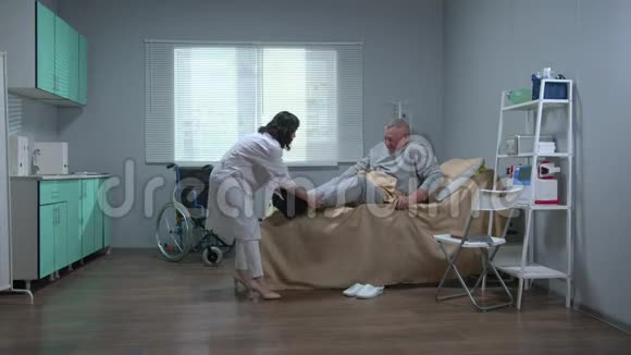 穿白色制服的医生帮助老病人起床视频的预览图