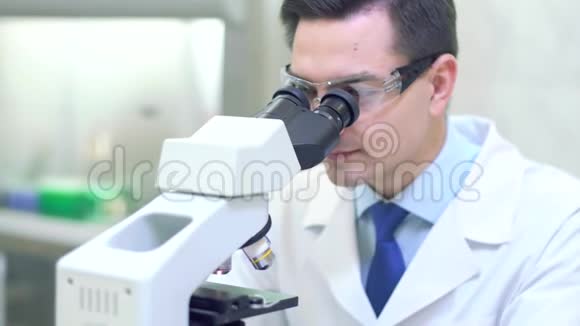 科学家在医学实验室通过显微镜进行科学研究视频的预览图