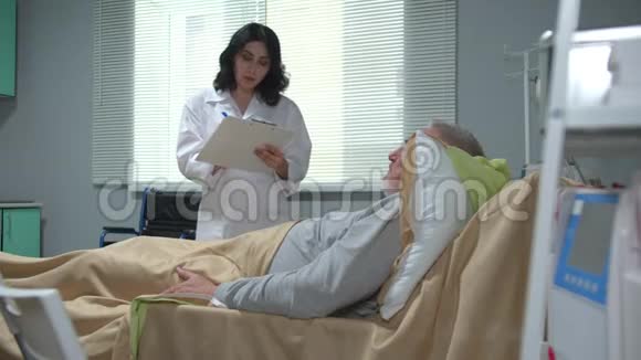 医生拿着文件向躺在医院床上的人解释了一些事情视频的预览图