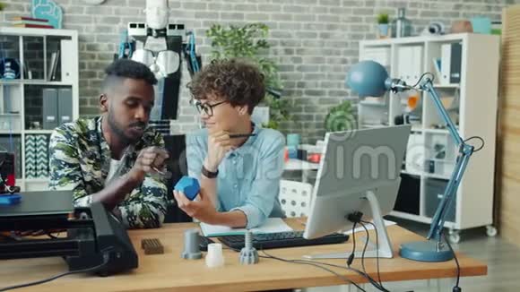 制作机器人谈话3d打印细节的年轻专家在办公室工作视频的预览图