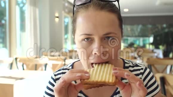 一位女士正在酒店餐厅吃早餐她正在吃烤面包视频的预览图