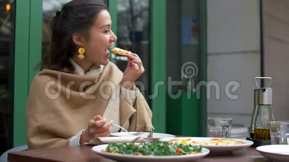 迷人的年轻混合女人吃披萨和微笑4k视频的预览图