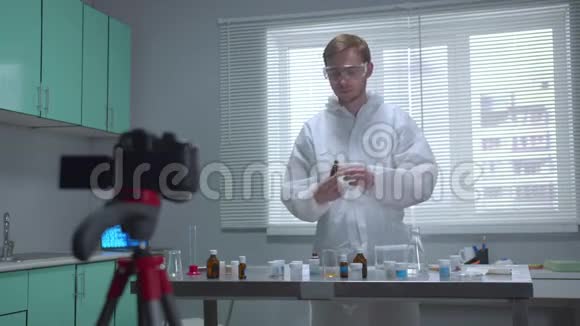 穿着防护工作服的人在实验室里用摄像机展示他的作品视频的预览图