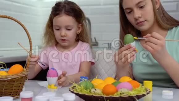 复活节快乐两个姐妹画复活节彩蛋为复活节做准备的快乐家庭孩子可爱的小女孩视频的预览图