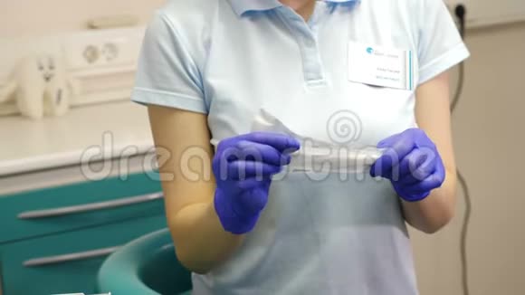 用无菌镜和定标器工具打开手套包装的女牙医特写镜头医疗准备视频的预览图