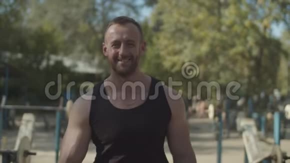 微笑的健美运动员在户外健身房散步视频的预览图
