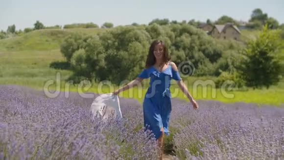 戴着帽子的女人在薰衣草的田野里奔跑视频的预览图