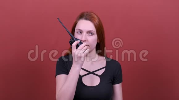 红头发的年轻女子对着对讲机说话视频的预览图