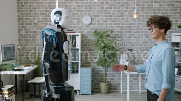 现代办公中年轻女性开发者的智能机器人模仿动作视频的预览图